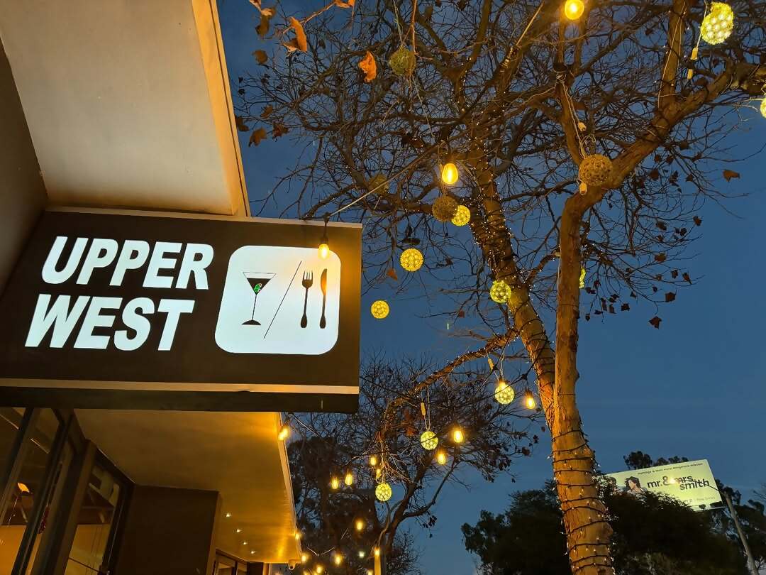 Upper West restaurant sign and string lights